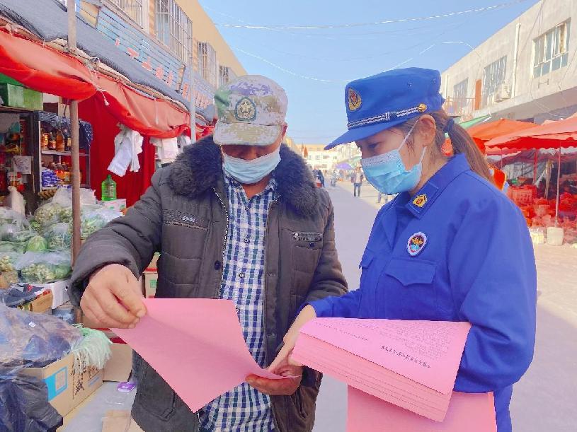 消防宣传员在岳普湖县新农贸市场巴扎天向过往市民发放宣传资料 (1)