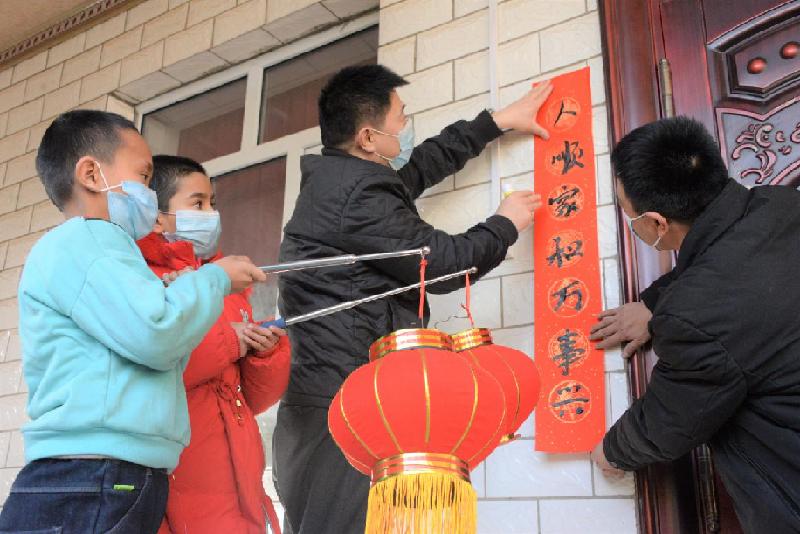 驻库车市工作队同村民一起贴春联。董建峰