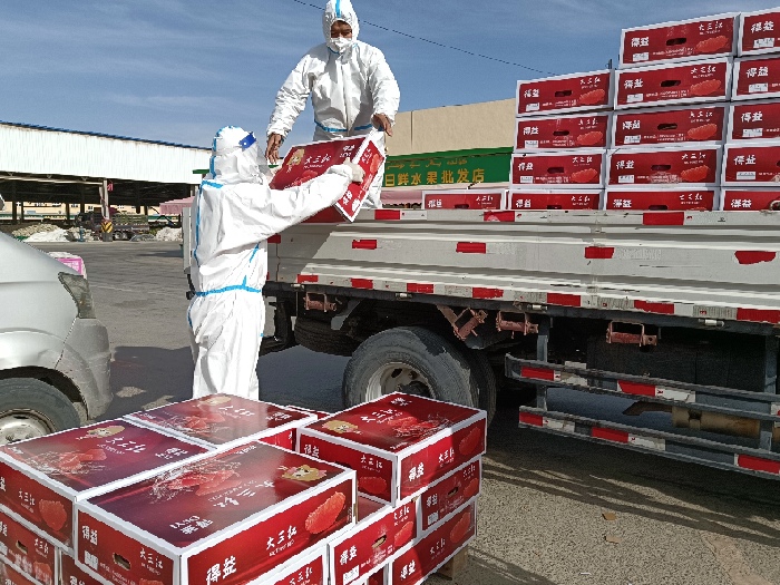 商户贾宝玉正在将水果装上货车