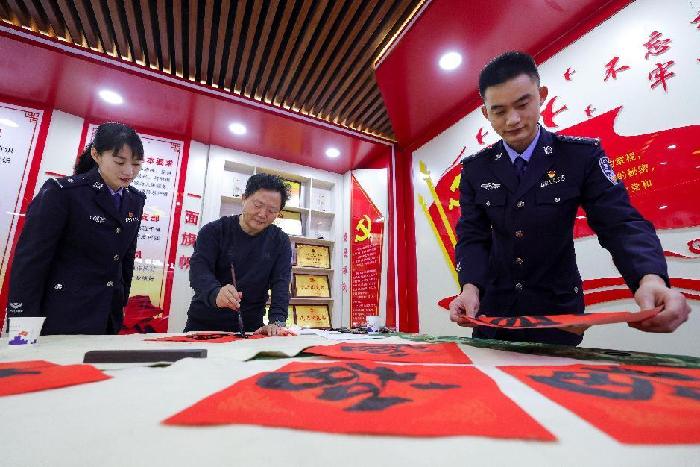 图为移民管理警察向书法家学习书画技巧 梅俊豪摄3