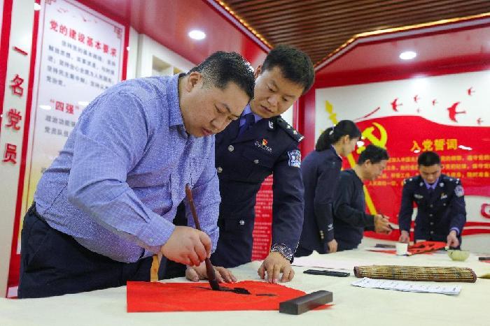 图为移民管理警察向书法家学习书画技巧 梅俊豪摄2