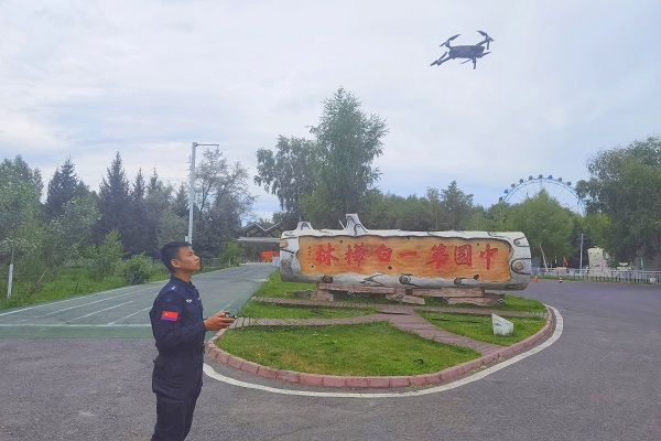民警利用无人机对哈巴河县白桦林景区的治安状况进行巡查