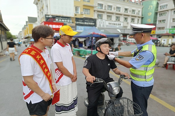 交警为未佩戴头盔人员佩戴头盔