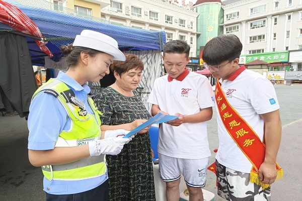 交警与志愿者为行人进行交通安全宣传