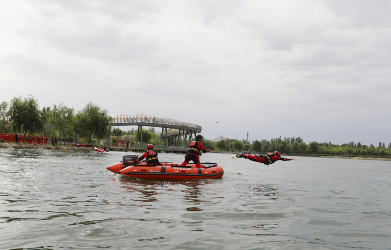 图为演练现场消防救援人员入水。