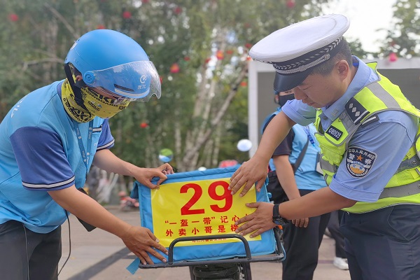 民警为快递小哥车体后部车厢张贴放大号 实行一人一车一证一车管理