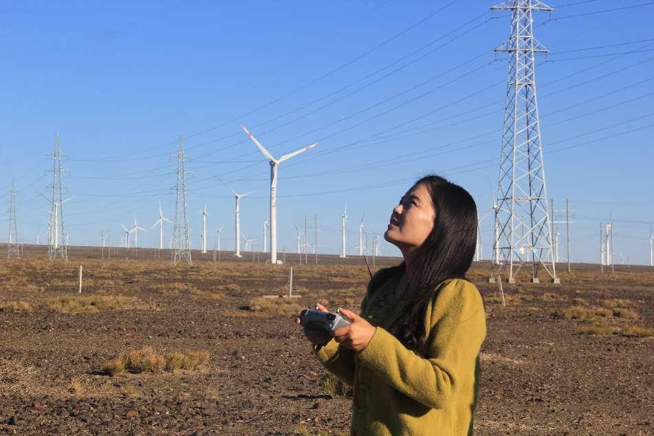 图为：10月17日，六师五家渠市文联摄影家协会会员张静正在北塔山风力发电机场航拍。  于三 摄