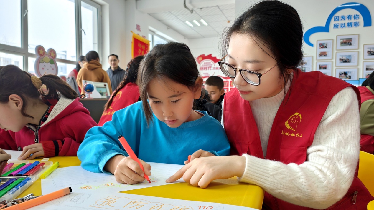 C:\Users\Administrator\Desktop\新建文件夹 (4)\新建文件夹 (3)\12月16日，察布查尔镇石榴籽小课堂内，来自盐城师范学院实习支教大学生志愿者正在教孩子们练习给父母亲写信。华岩明摄3c6f56f543e5120818014ab06bd97f7.jpg