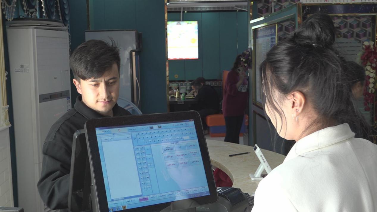 麦麦提艾则孜&middot;艾力正为客户服务