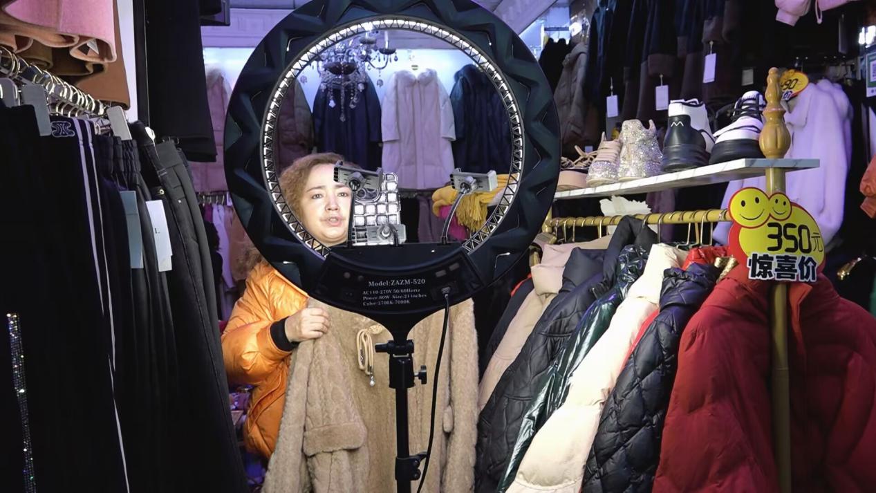 努尔妮莎·麦麦提吾拉伊木在直播间推销自己店里的服装。