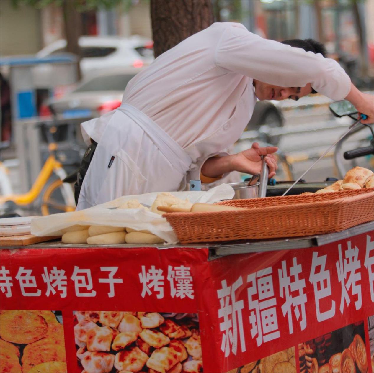 凯尤木·艾克木江在成都用流动馕坑忙着打馕