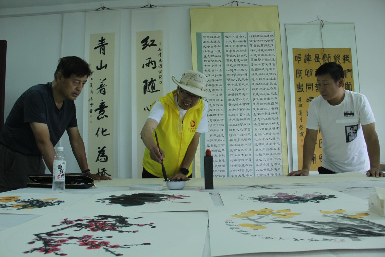 图为:2022年7月,山西晋城书画家和芳草湖农场本土书画家,在团结北路社区开展创作交流。 于三 摄