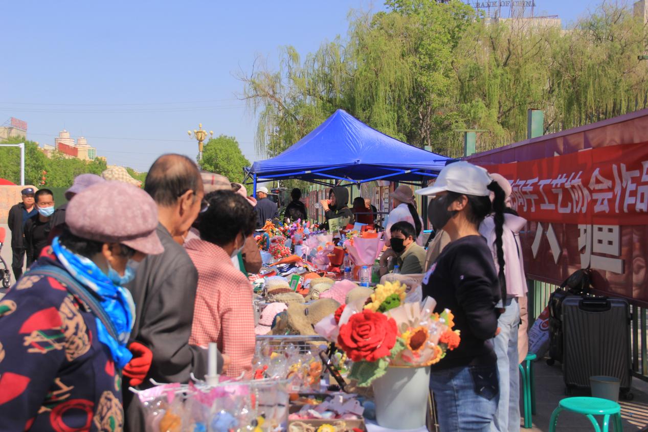 图为：芳草湖农场居民在手工艺品展示区参观。 于三 摄