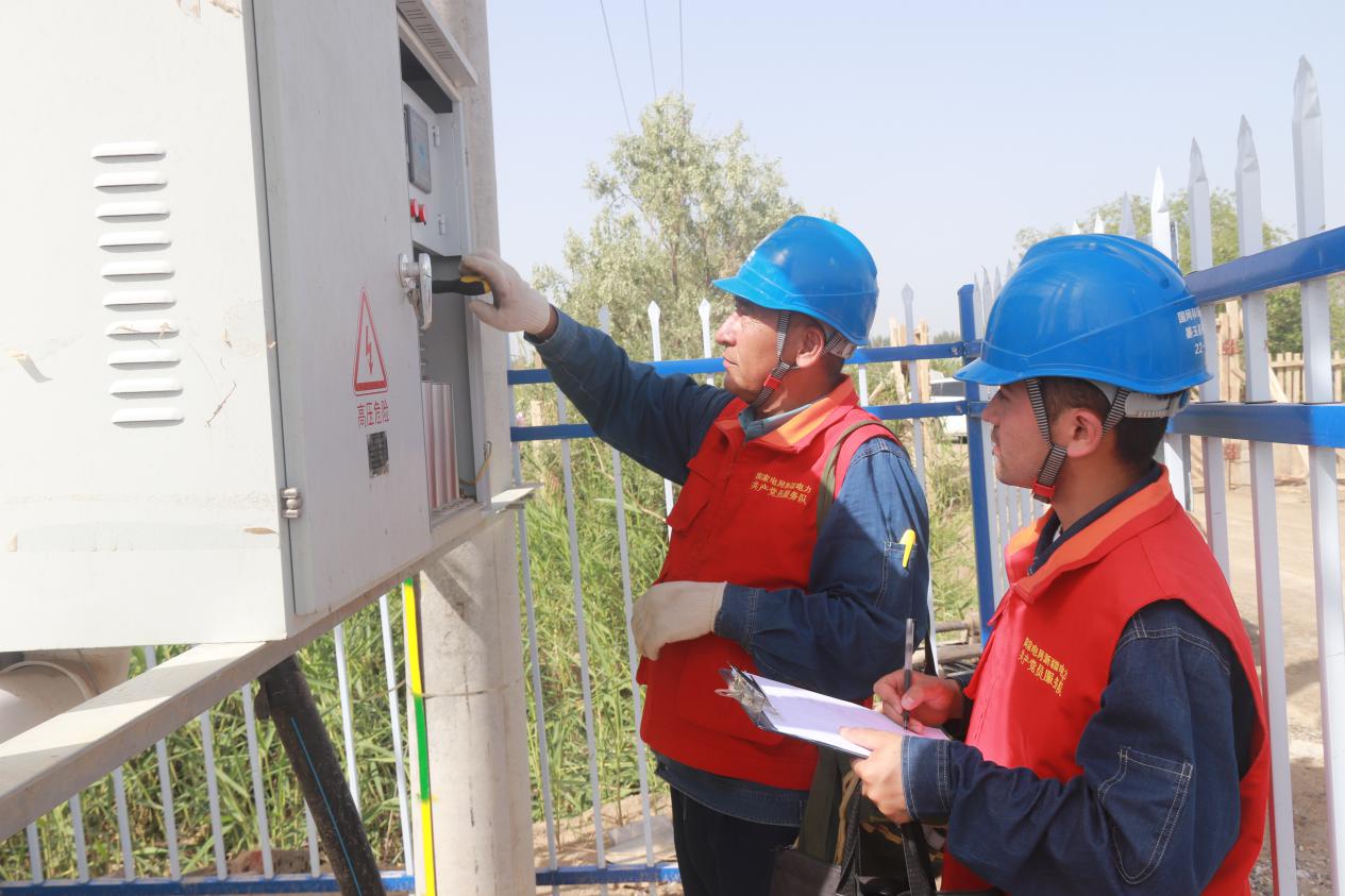国网墨玉县供电公司工作人员正在检查配电箱等用电设备