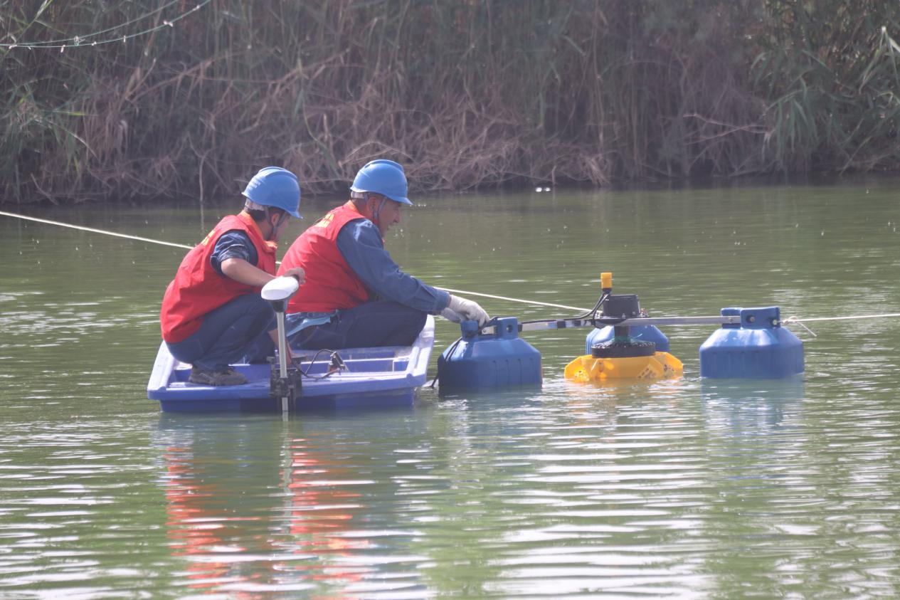 国网墨玉县供电公司工作人员正在检查鱼塘设备