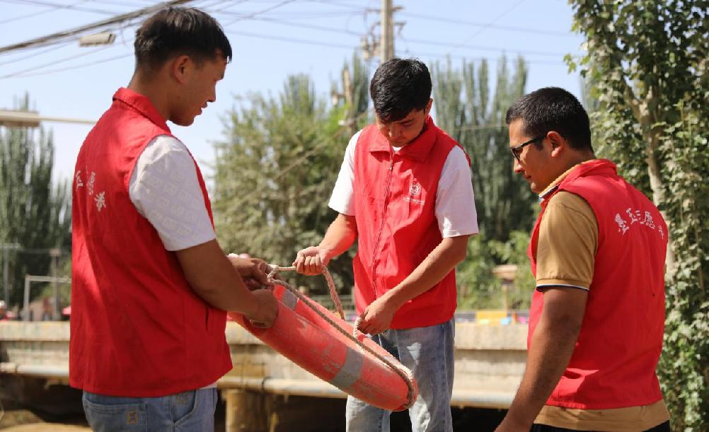 阿卜杜热合曼·阿卜力孜和同事检查救生圈的性能是否正常。
